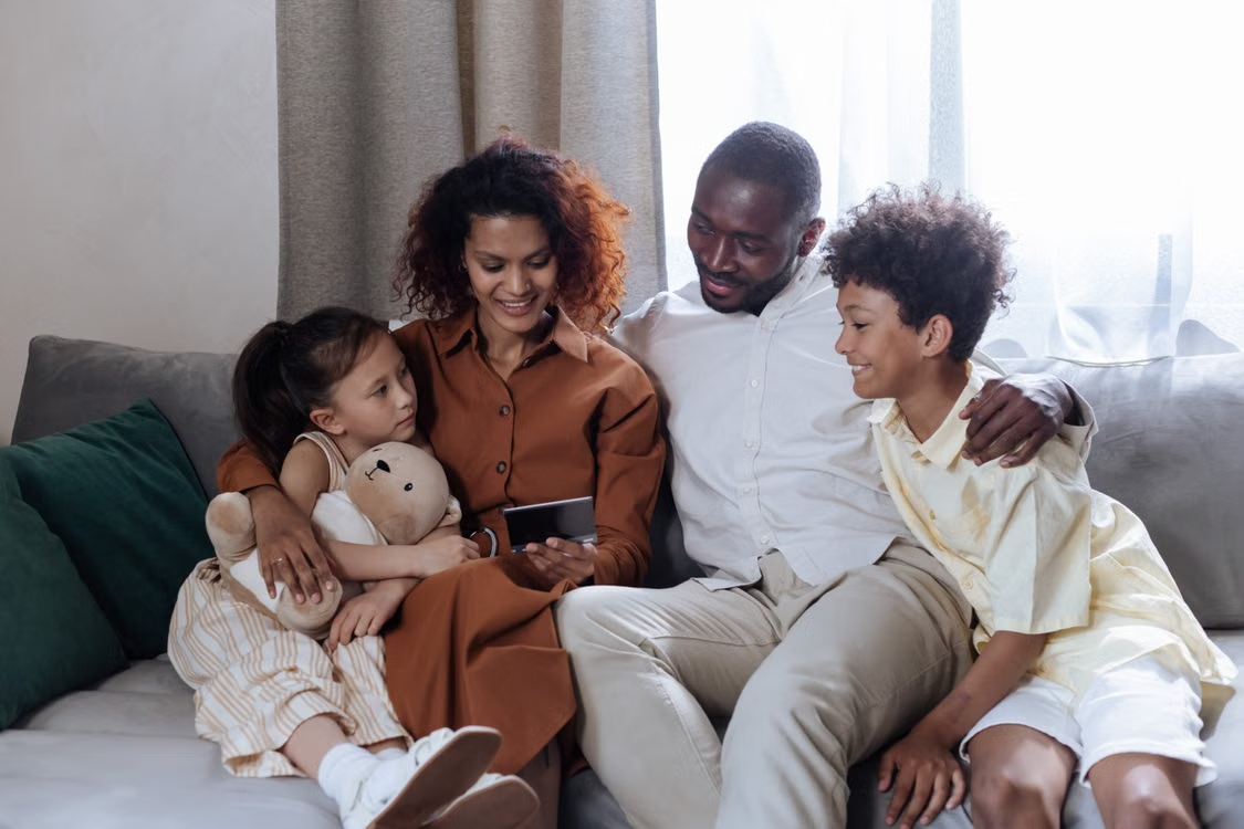 Une famille réunie sur un canapé, souriante